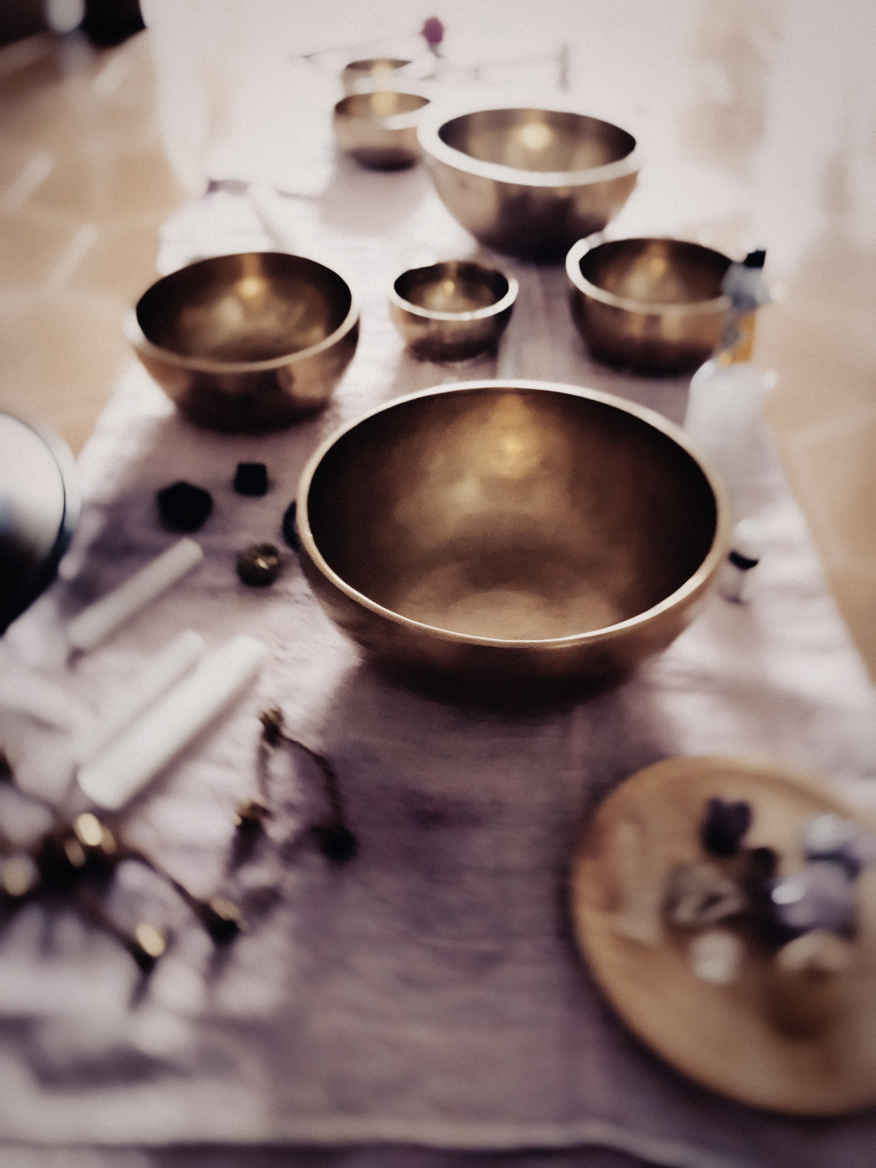 A close view of a metal singing bowl among other instruments.