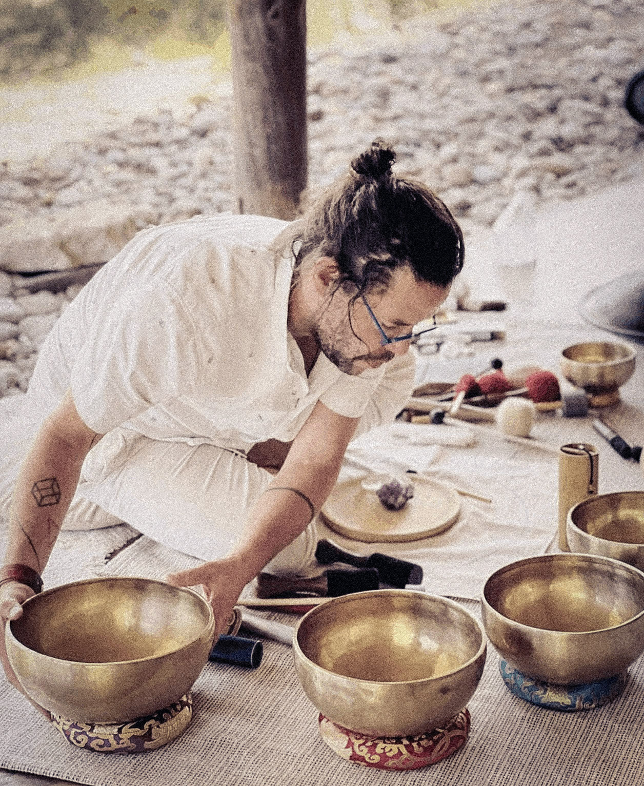 Diego arranging a metal bowl among instruments before a session.