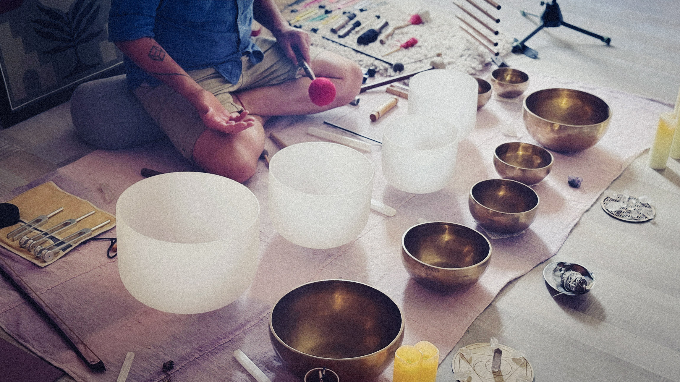 A wide arrangement of crystal bowls, metal bowls and chimes during a session.
